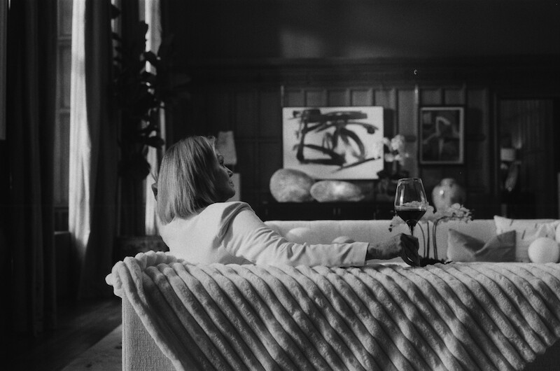 Black-and-white image of Joanna Lumley as Judith Baker sitting on a couch in Season 1 of 'Fool Me Once'
