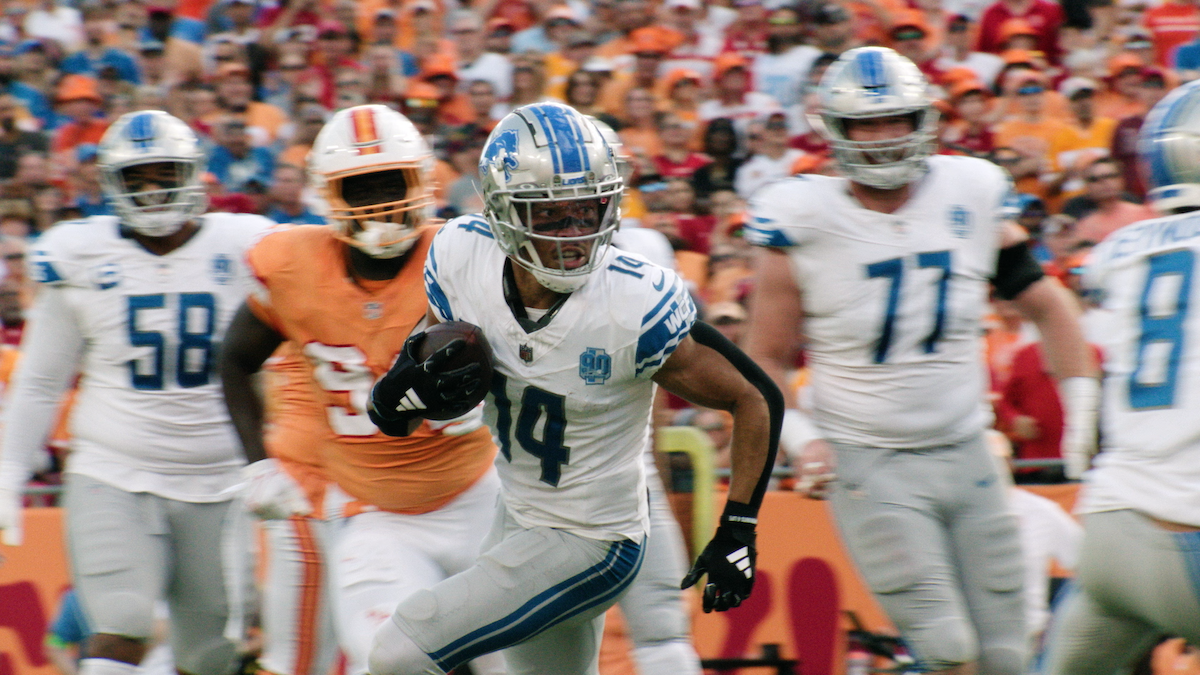 Amon-Ra St. Brown carries the ball during a game.
