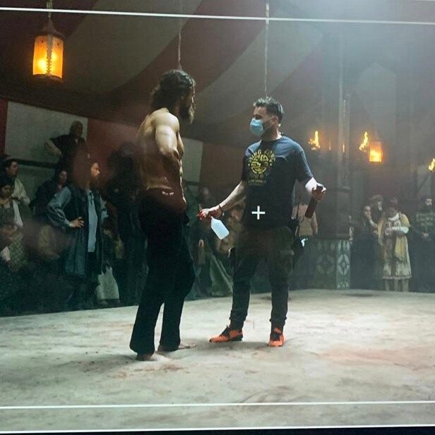 Makeup and prosthetics designer Tom McInerney prepares to apply the ab glow mixture, which includes glycerin and water, to shirtless actor Leo Suter at Ashford Studios in County Wicklow, Ireland, where ‘Vikings: Valhalla’ was filmed.