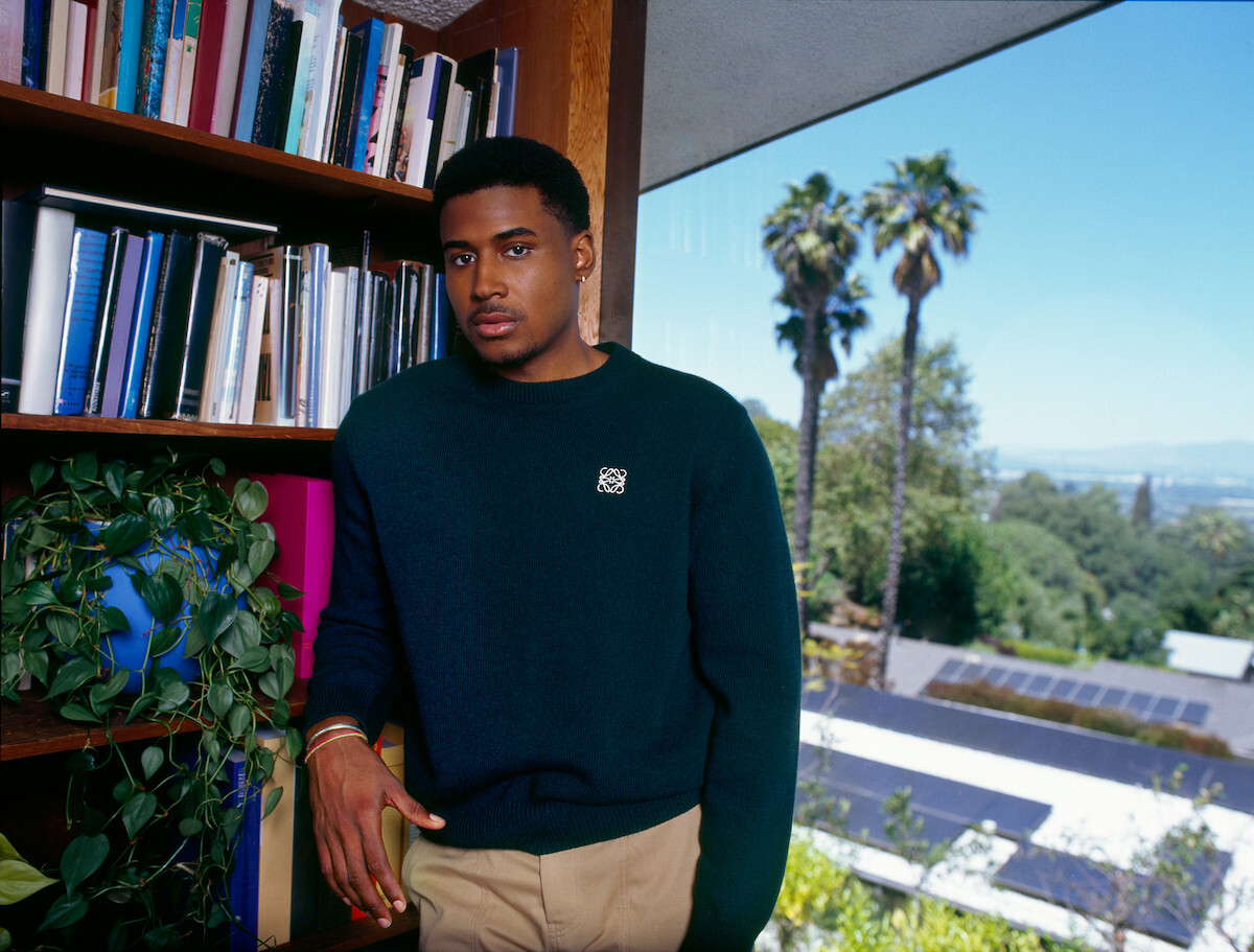Michael Cooper leans against a bookshelf.