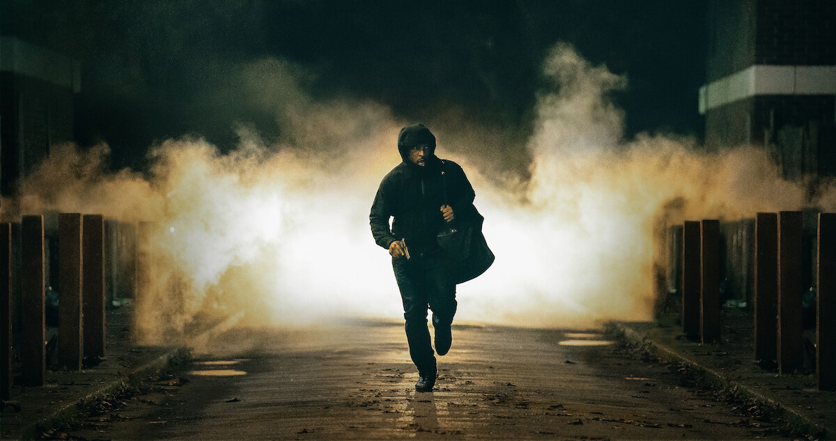 Ashley Walters as Dushane runs down the street at night in Season 3 of ‘Top Boy.’
