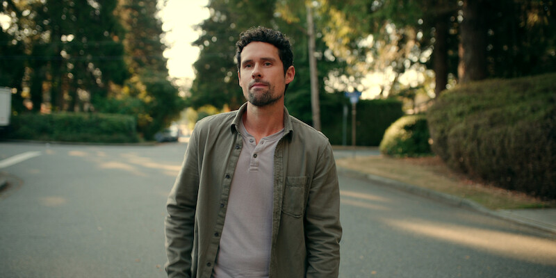 Benjamin Hollingsworth as Brady stands in the street wearing a green jacket in Season 5 of ‘Virgin River.’