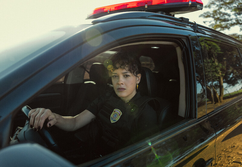 A woman in a police uniform sitting in the driver's seat.