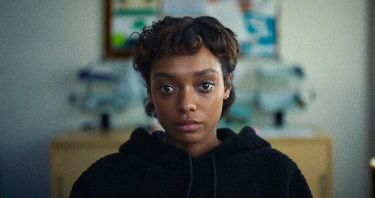 Sophie Wilde as Mia sits wearing a black sweatshirt in Season 1 of 'Everything Now.'