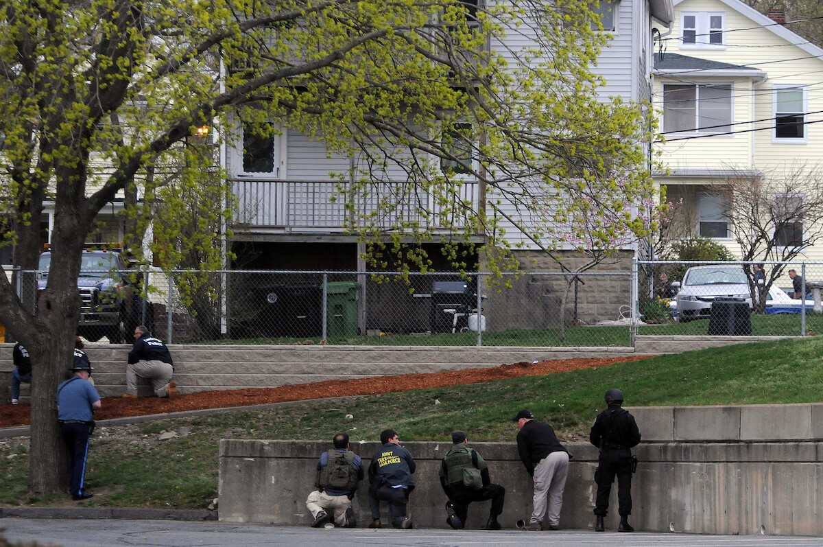 Law enforcement approach an area where a suspect is hiding in Watertown, Massachusetts.