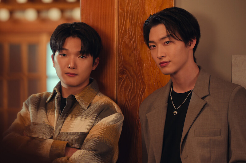 Minyeong Choi as Dae Heon Kim and Sang Heon Lee as Min Ho Moon lean against a wall in Season 2 of 'XO, Kitty'