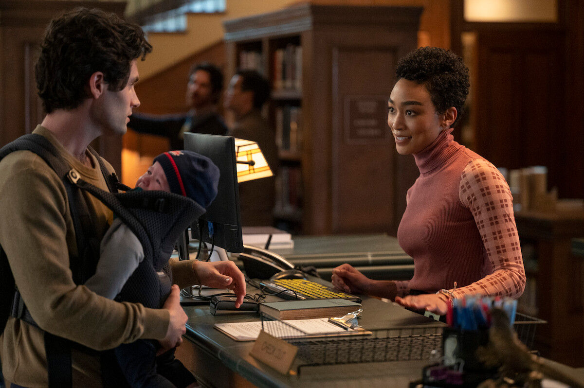 Penn Badgley as Joe Goldberg and Tati Gabrielle as Marienne talking in a library in You Season 3