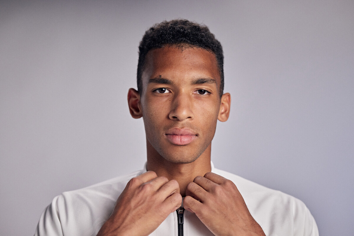 Félix Auger-Aliassime adjusts his collar.