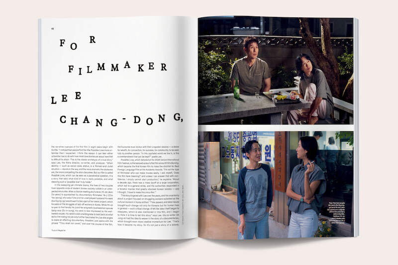 Magazine spread with text about filmmaker Lee Chang-dong on the left page, and two photos on the right: two people conversing at a table outdoors at night, and two women talking on a street outside a building.