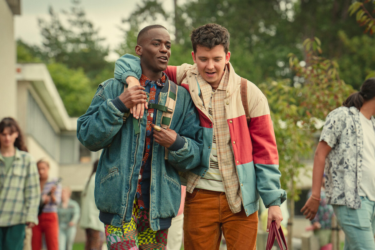 Ncuti Gatwa as Eric and Asa Butterfield as Otis walk to school together in Season 4 of ‘Sex Education.’ 