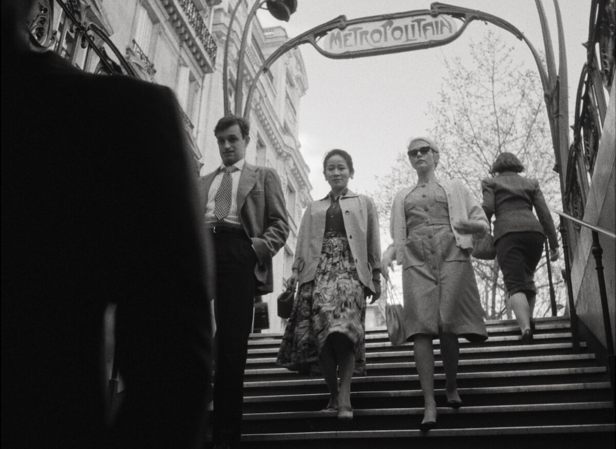 Jean-Paul Belmondo (Aubry Dullin), Phuong Maittret (Jade Phan-Gia), and Jean Seberg (Zoey Deutch) enter a metro station in Paris.