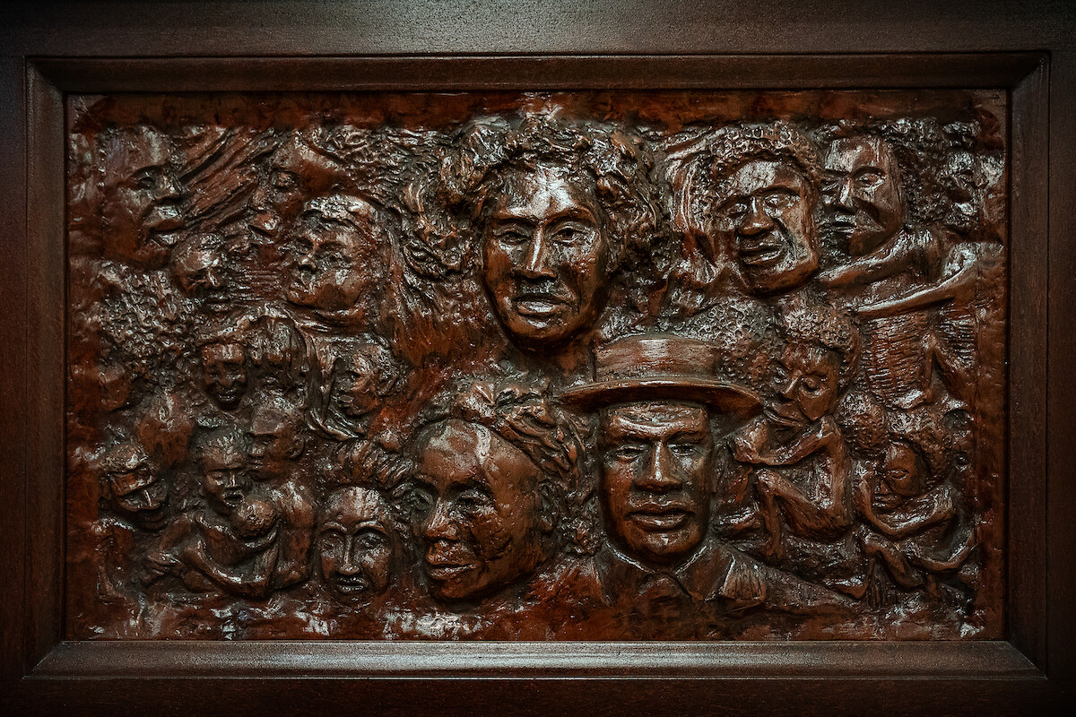 A detailed photograph of the piano from The Piano Lesson, featuring the faces of family ancestors carved into the wood.