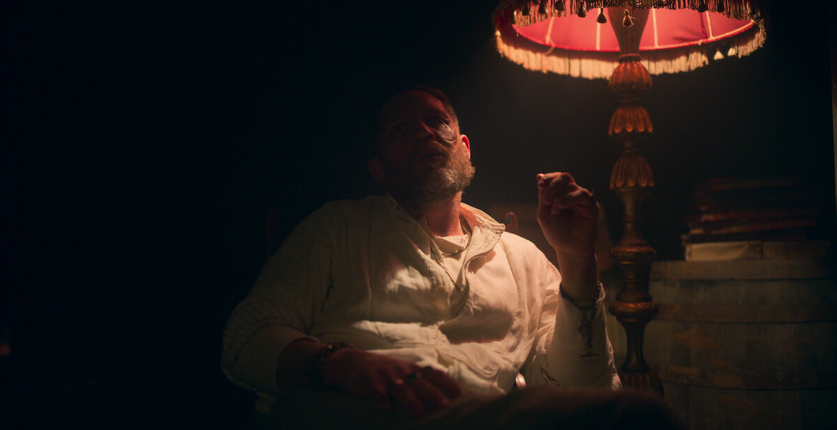 Alfie Solomons, played by Tom Hardy, smokes in the shadows