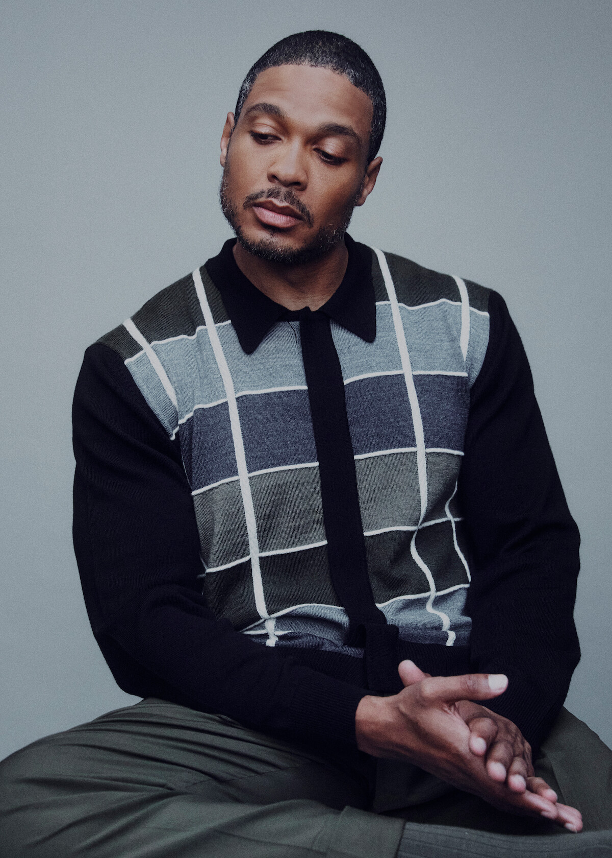 Ray Fisher wears a plaid shirt and gray pants.