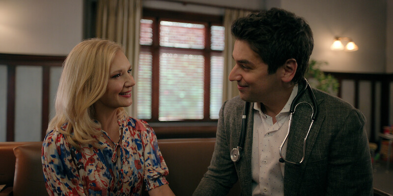 Teryl Rothery as Muriel St. Claire and Mark Ghanime as Dr. Cameron Hayek sit together smiling in Season 5 of ‘Virgin River.’