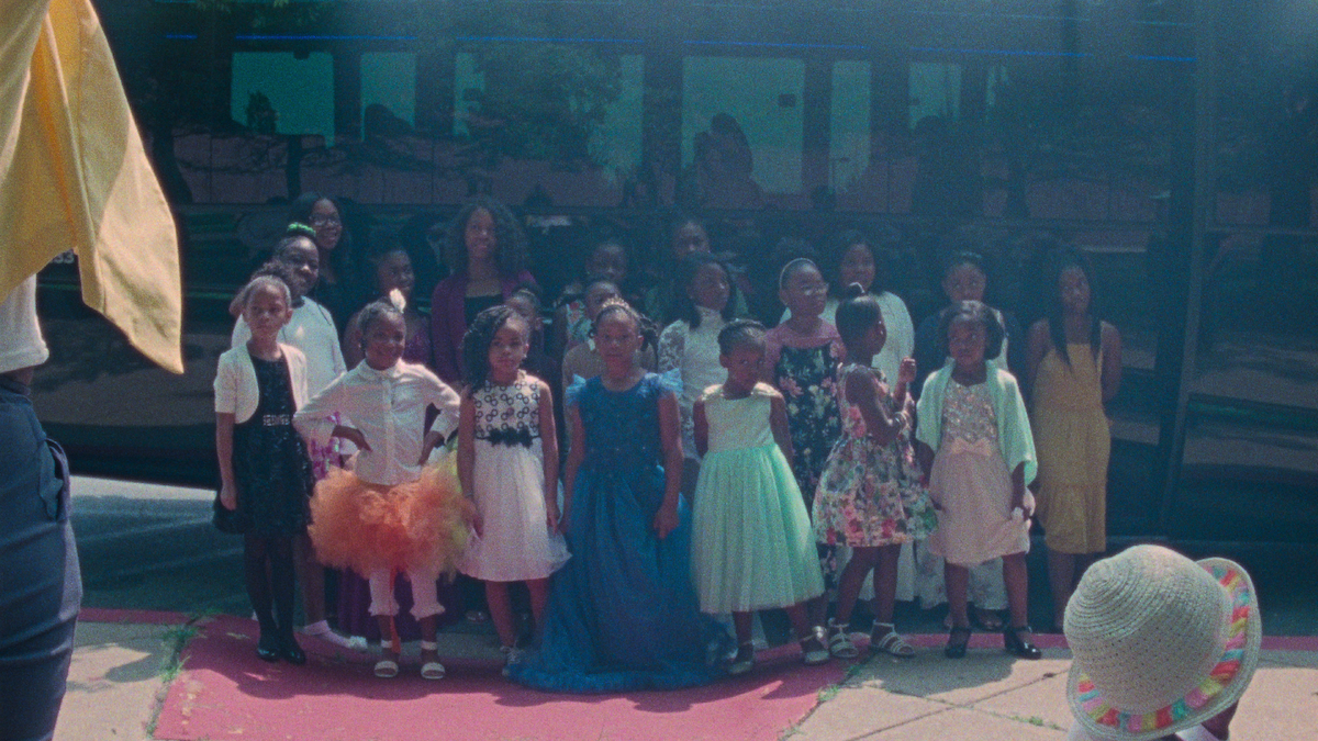 A group of young girls stand together outside.