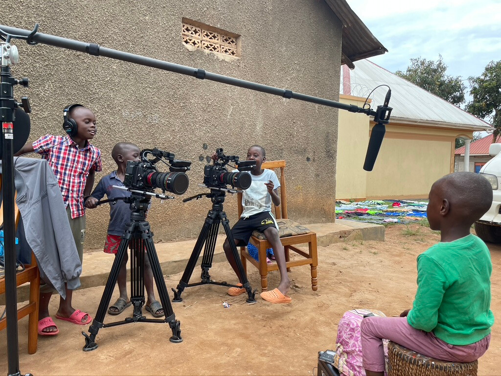 A group of kids playing with camera equipment.