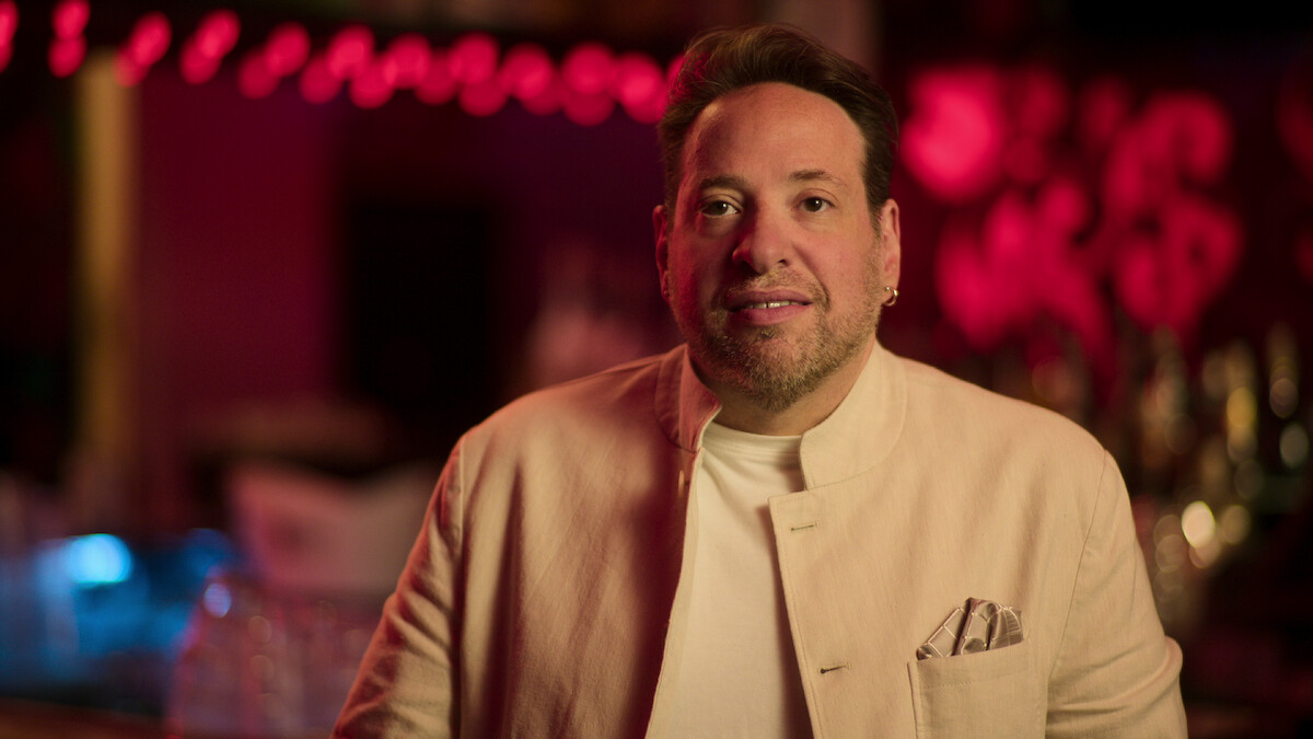 Stuart wearing a white blazer. 