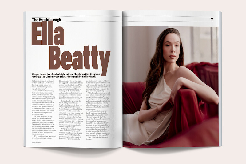 Magazine spread featuring an article about Ella Beatty with large bold text on the left and a portrait of a woman in an elegant cream dress sitting on a red couch in a softly lit indoor setting on the right.