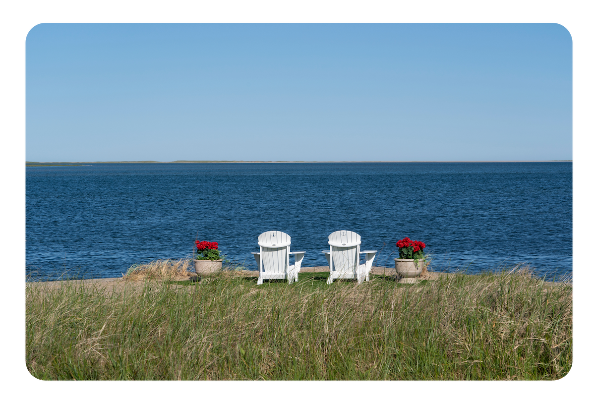Two beach chairs looking out toward the water in ‘The Perfect Couple’