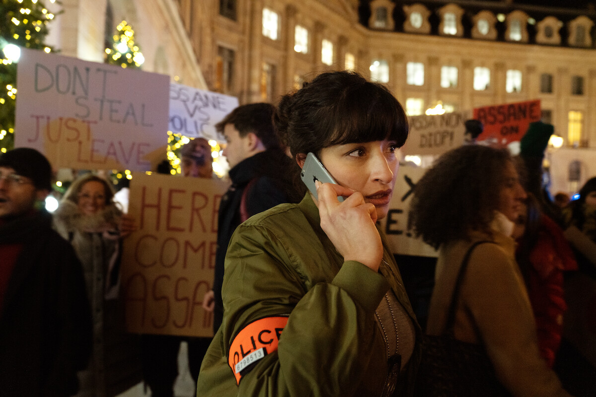 Shirine Boutella as Sofia Belkacem walks through a crowd while on a phone call in Season 3 of ‘Lupin.’