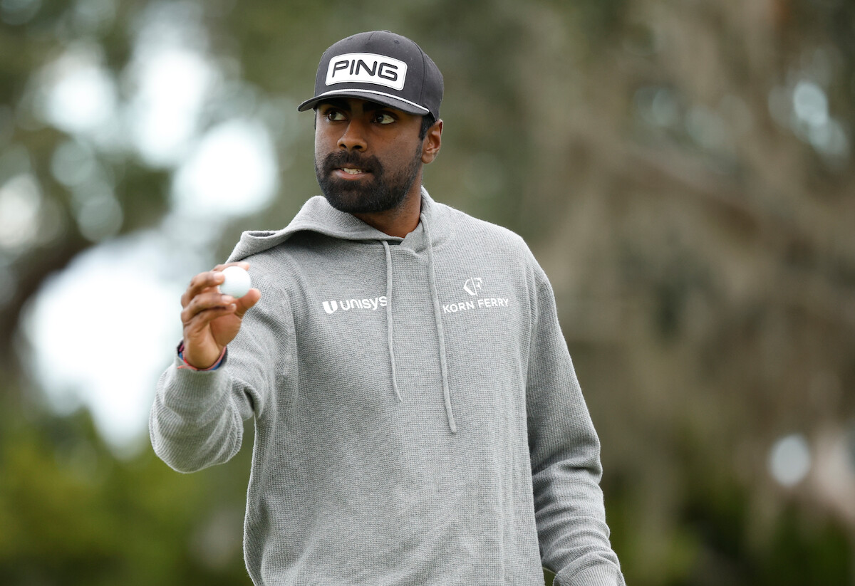Golfer Sahith Theegala holds onto a golf ball during an event.