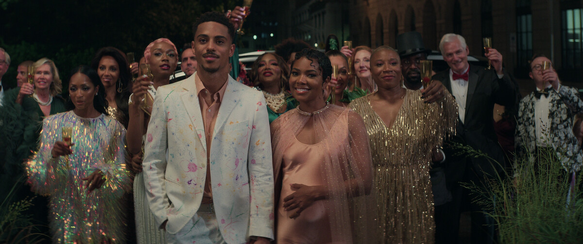 Keith Powers (left) and a pregnant Gabrielle Union (right) hold hands at Darzine’s Gala in a still from ‘The Perfect Find.’