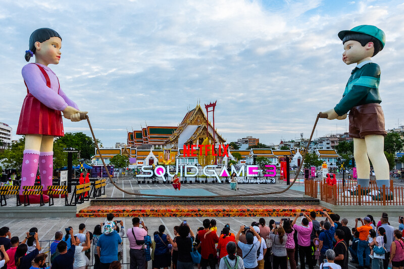 Fans cheer on competitors during the Giant Jump Rope Game at a 'Squid Game' Season 3 event in Bangkok.