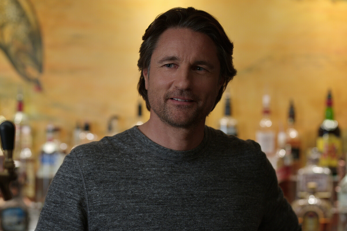 Martin Henderson looks at someone with a slight smile on his face.