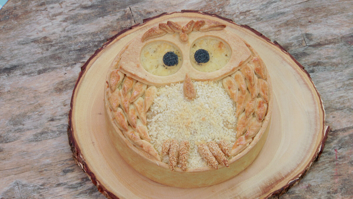 A pie filled with two different types of cheeses, and shaped like an owl