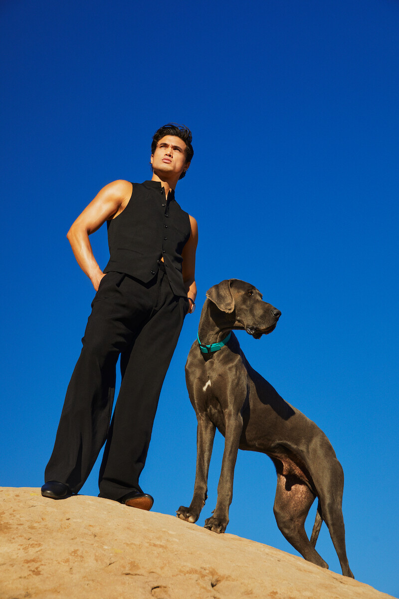 Charles Melton poses with a dog.