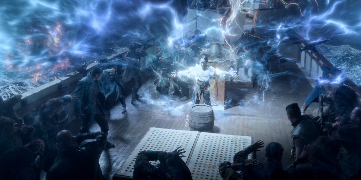 Jessie Mei Li as Alina Starkov outstretches her arms as a cloud of purple and blue light surrounds her in Season 2 of ‘Shadow and Bone.’