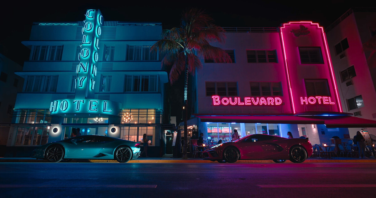 Sports cars parked outside of a hotel.