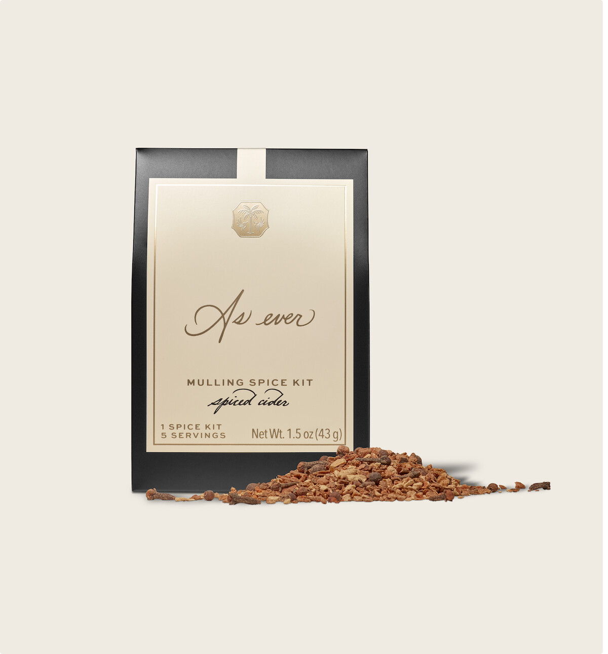 Elegant packet of "As Ever" mulling spice kit labeled for spiced cider, set against a neutral background with a serving of loose spices spilled in front. The mood is warm and inviting, suggesting coziness and seasonal comfort.