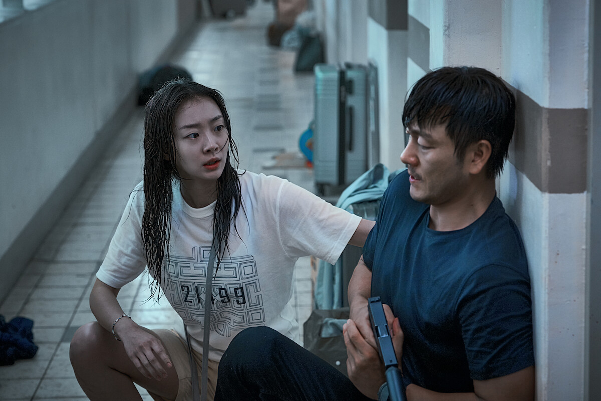 Kim Da-mi, as Koo An-na, and Park Hae-soo, as Son Hee-jo, fight through the crowd in ‘The Great Flood.’