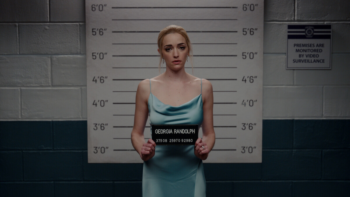 Brianne Howey em frente a uma fila de suspeitos da polícia.