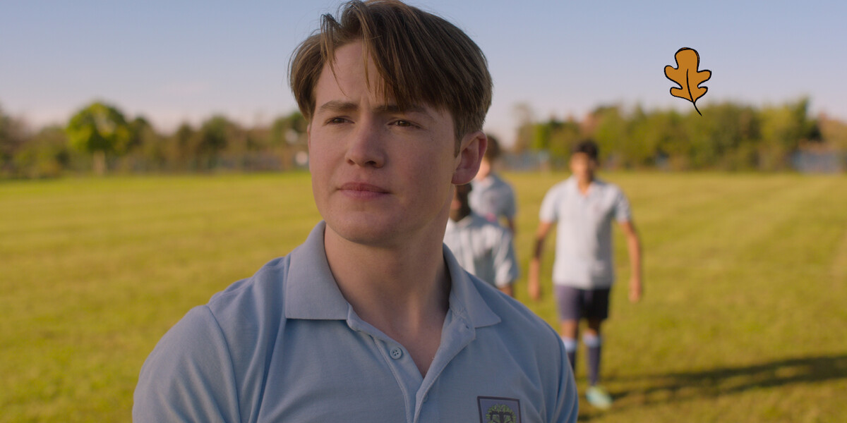 Kit Connor as Nick stands on a field wearing a rugby uniform in Season 2 of ‘Heartstopper.’