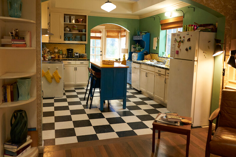 Kitchen with black and white tiles, blue counter island. 