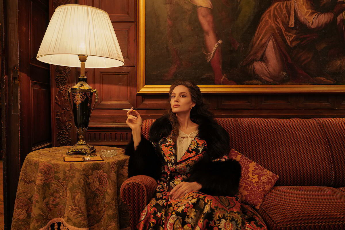 Angelina Jolie as Maria Callas smoking a cigarette on a sofa