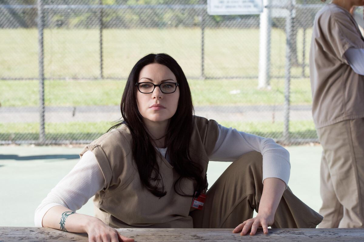 Laura Prepon as Alex Vause sits outside in a prison uniform in Season 3 of ‘Orange Is the New Black.’ 