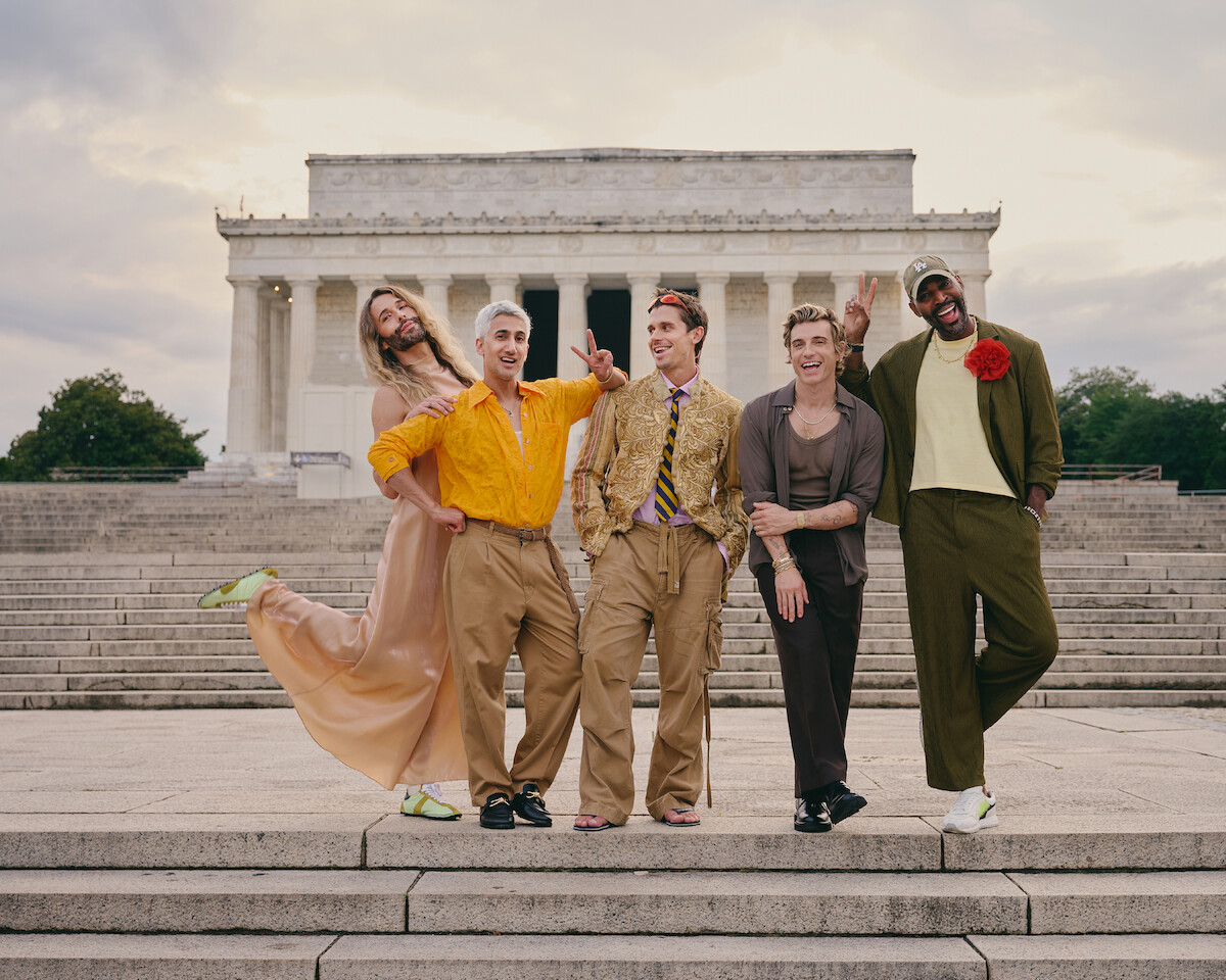 Five people pose happily in colorful, fashionable clothing on the steps outside the Lincoln Memorial at sunset, smiling and making playful gestures, with the historic monument in the background.
