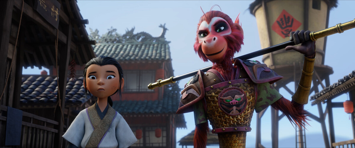 A young girl and a human sized monkey wearing armor stand in a medieval Chinese village in a still from ‘The Monkey King.’ 