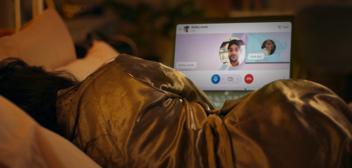A woman lies on a bed while looking at a laptop in 'Sweet Bobby: My Catfish Nightmare'
