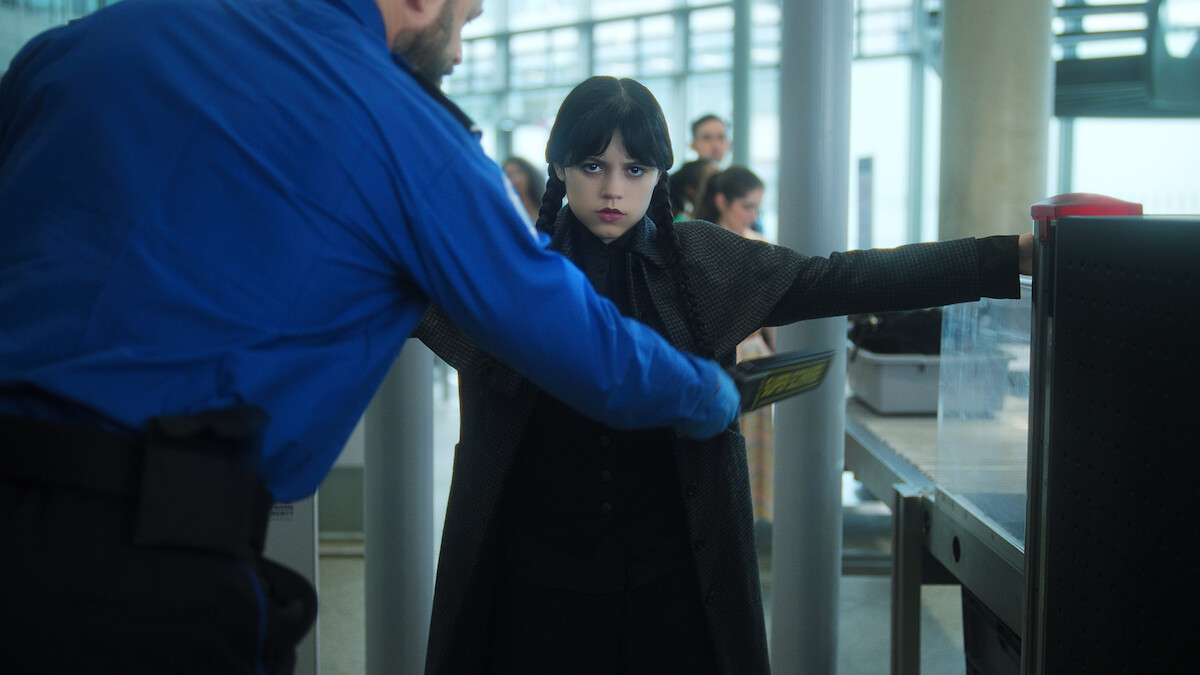 Jenna Ortega as Wednesday gets searched at airport security in Season 2 of ‘Wednesday’