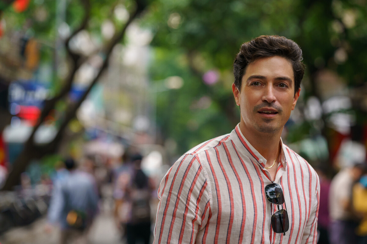 A man stands on a busy street in a still from ‘A Tourist’s Guide to Love.'