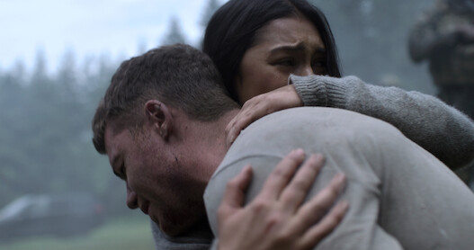 Gabriel Basso como Peter Sutherland e Luciane Buchanan como Rose se abraçam em ‘O Agente Noturno’
