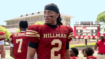 Cornell Young IV as Shaquille in a red Hillman jersey stands on the field with teammates in 'A Different World'