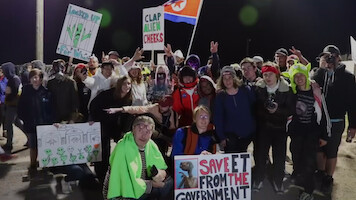 A group of people posing for a picture and holding signs