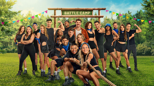 The cast of 'Battle Camp' Season 1 playing tug of war under a Battle Camp sign.