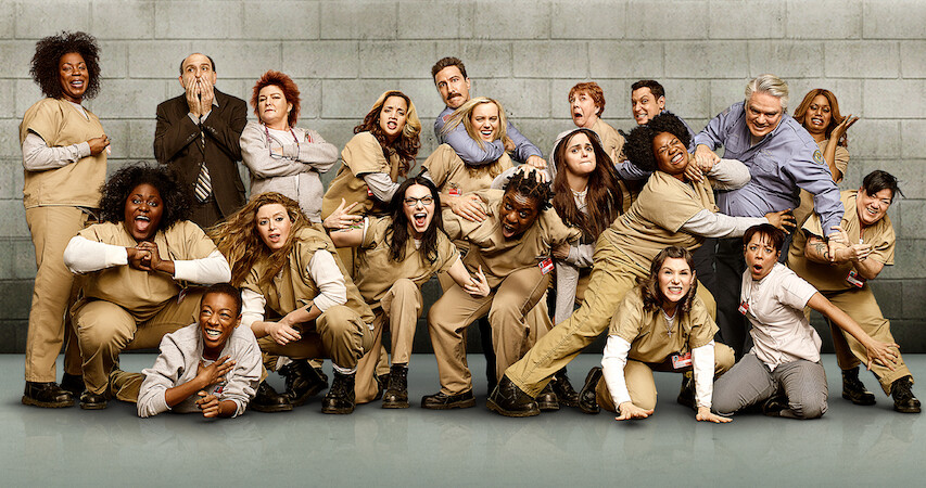 The cast of Orange Is the New Black Season 7 pose together playfully. 